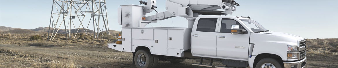 a commercial work truck at a work site in the desert near a power line.
